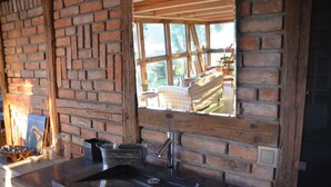 A rustic kitchen with a brick wall, a window, and a sink. - Reetdachkate on stud Schierensee - Fischerkate (Grebin)