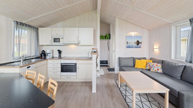 A compact living space with a kitchenette, a dining area, and a seating area with a sofa and a table. - Friedrichskoog-Deichblick 20 (Friedrichskoog)