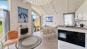 A spacious living area with a fireplace, dining table, and TV. - Friedrichskoog-Deichblick 20 (Friedrichskoog)
