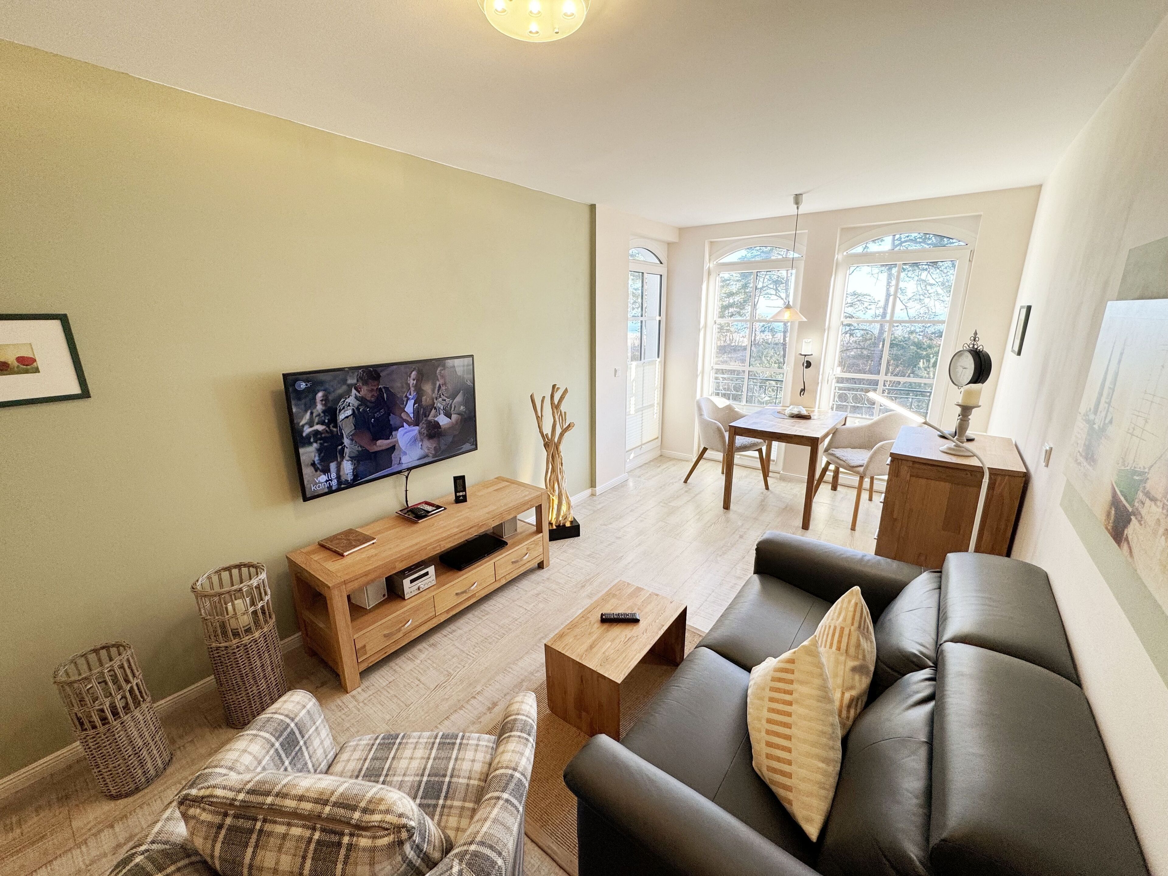 A living room with a TV, sofa, and dining area.