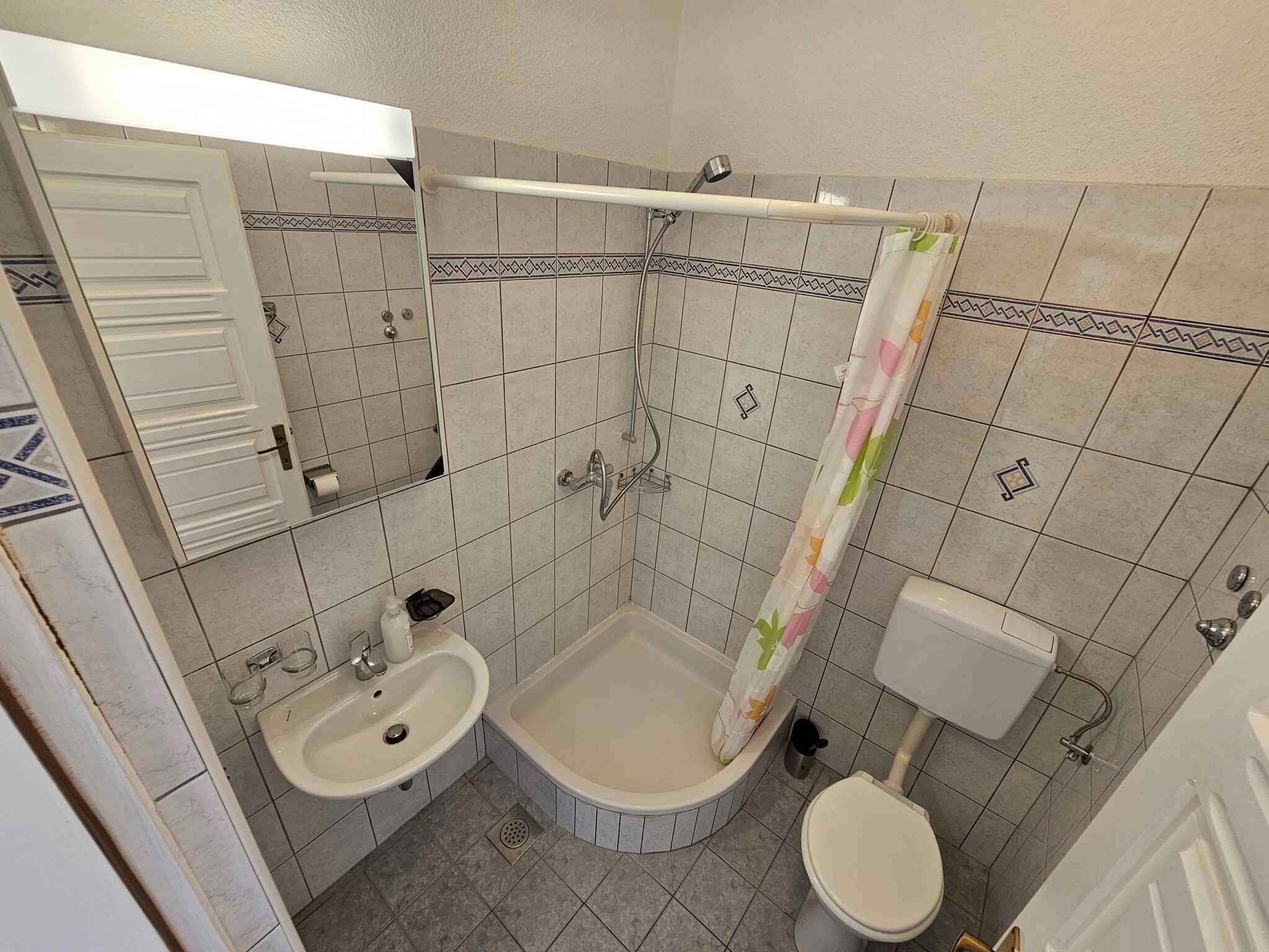 Ein kleines Badezimmer mit Toilette, Waschbecken und Dusche.