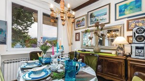 A dining area with a table set for four, a view of the outdoors, and various decorative items. - Cozy apartment in Rijeka with WiFi (Rijeka)