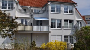 A two-story residential building with a red-tiled roof, white exterior walls, and multiple windows. - FeWo Möwennest / Felstehausen GM 69252 - FeWo Möwennest (Graal-Müritz)