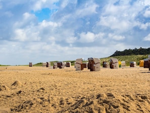 Uma praia com fileiras de cabanas de praia.