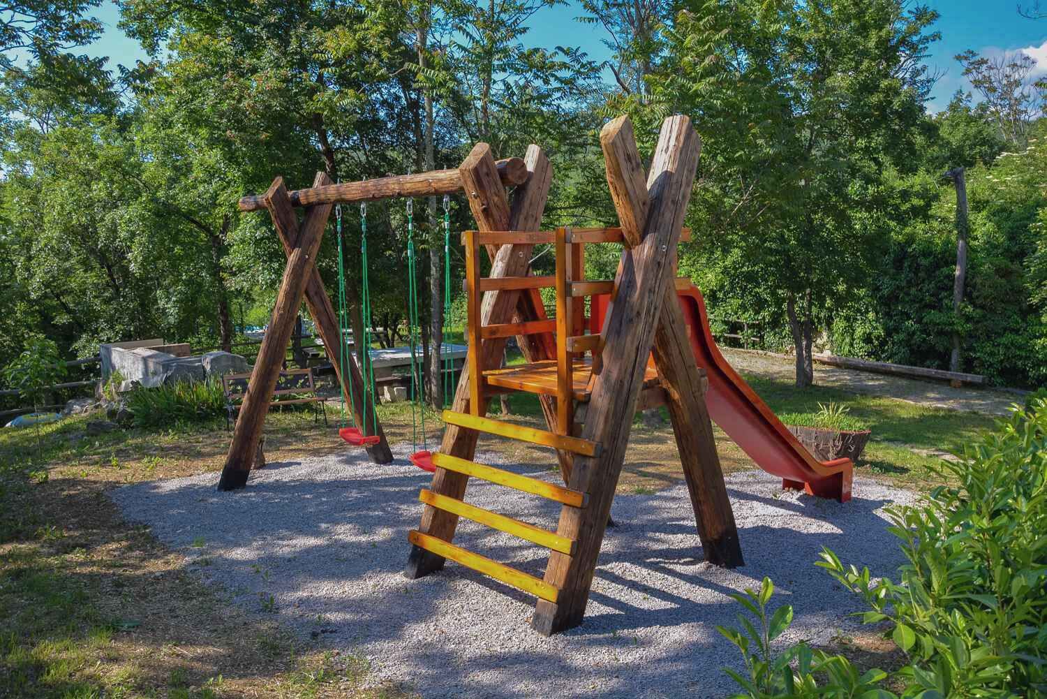 A wooden playground structure with a slide and a ladder.