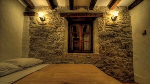 A room with a stone wall, a wooden window, and a bed. - Holiday home in a quiet location for nature lovers (Buzet)