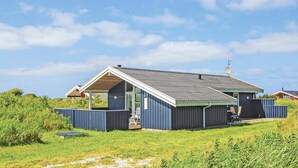 Una casa moderna con techo inclinado, un porche cubierto y una antena parabólica.