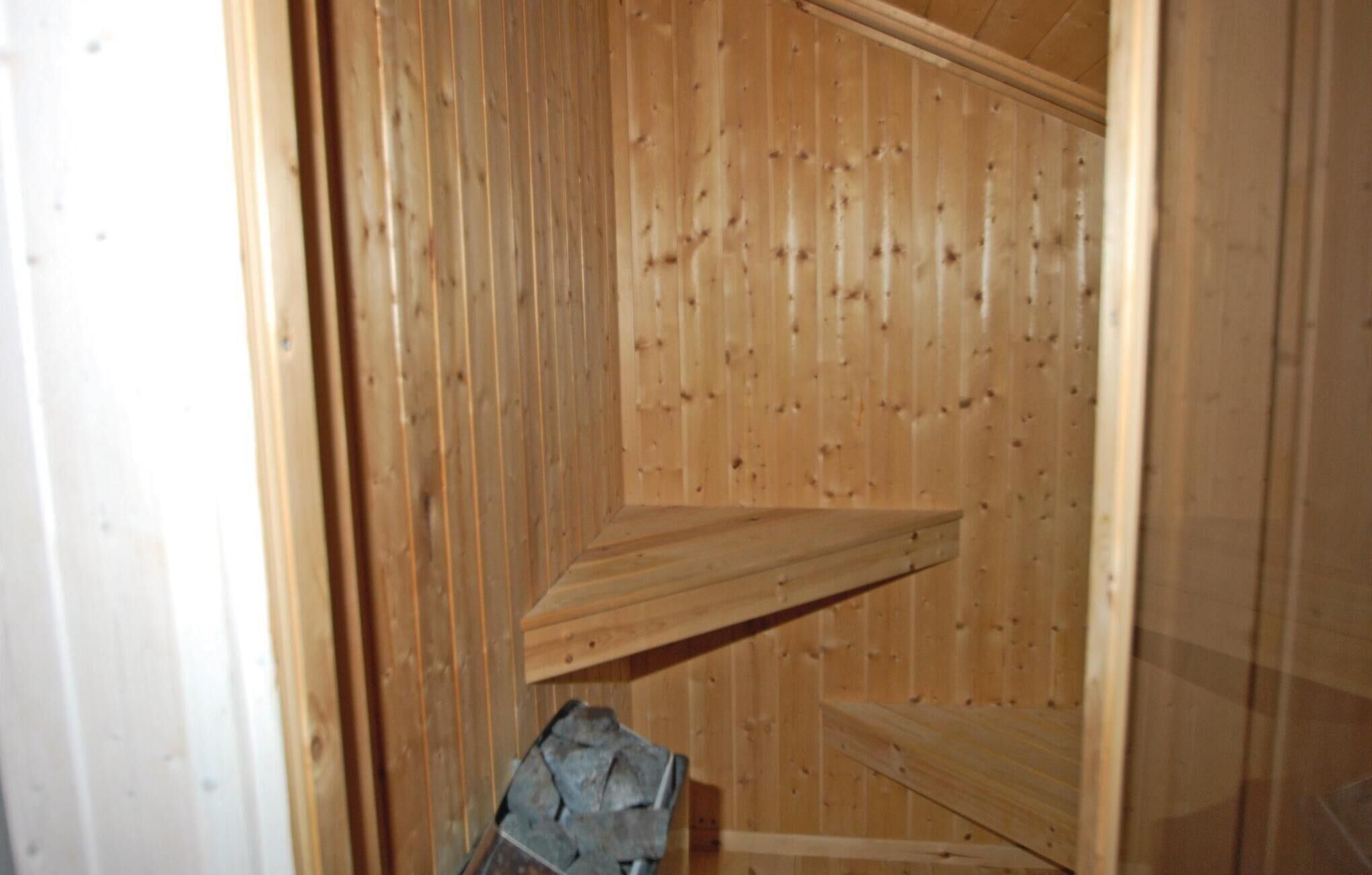 A wooden interior with a sloped ceiling and a built-in bench.