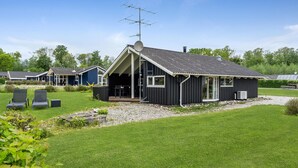 A modern house with a large deck, a satellite dish, and a chimney. - Awesome home in Juelsminde with sauna (Juelsminde)