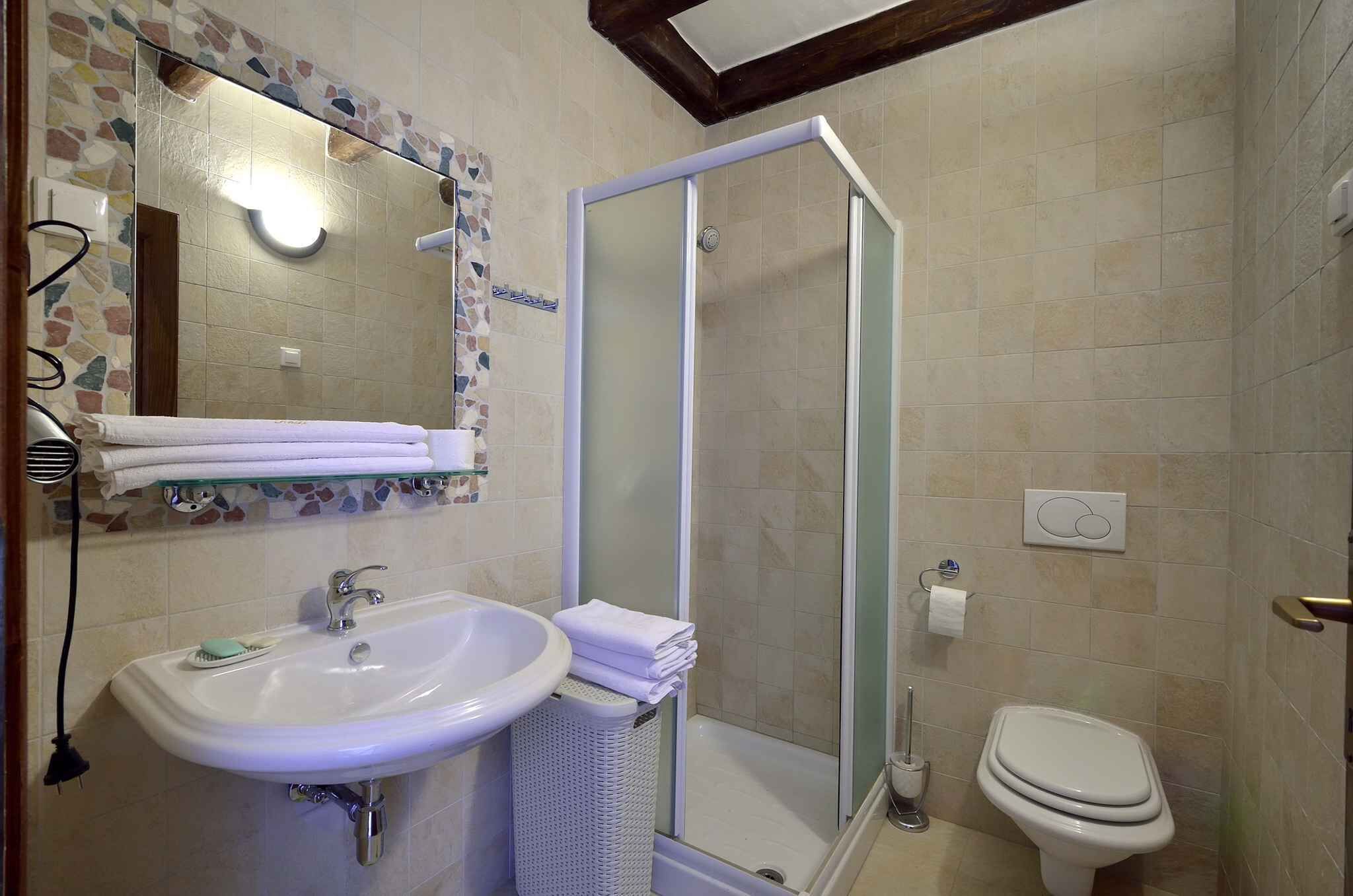 A bathroom with a white sink, a glass shower enclosure, and a toilet.