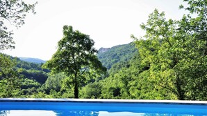 A swimming pool with a view of lush green hills and trees. - Holiday home in a quiet location and with barbecue (Buzet)