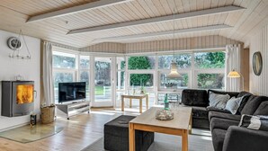 A modern living room with a fireplace, a television, and a cozy seating area. - 3 bedroom lovely home in Melby (Melby)
