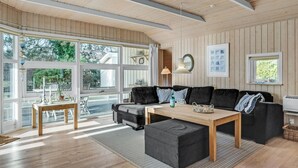 A modern living room with a large window, a sofa set, a coffee table, and a lamp. - 3 bedroom lovely home in Melby (Melby)