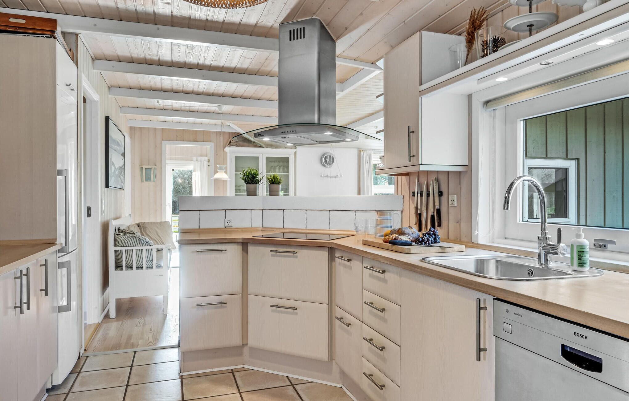 A modern kitchen with white cabinetry, a stainless steel sink, and a Bosch dishwasher. - 3 bedroom lovely home in Melby (Melby)