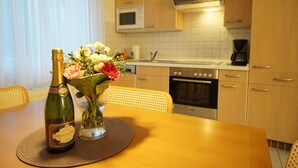 Ein Esstisch mit einer Champagnerflasche und einer Blumenvase.