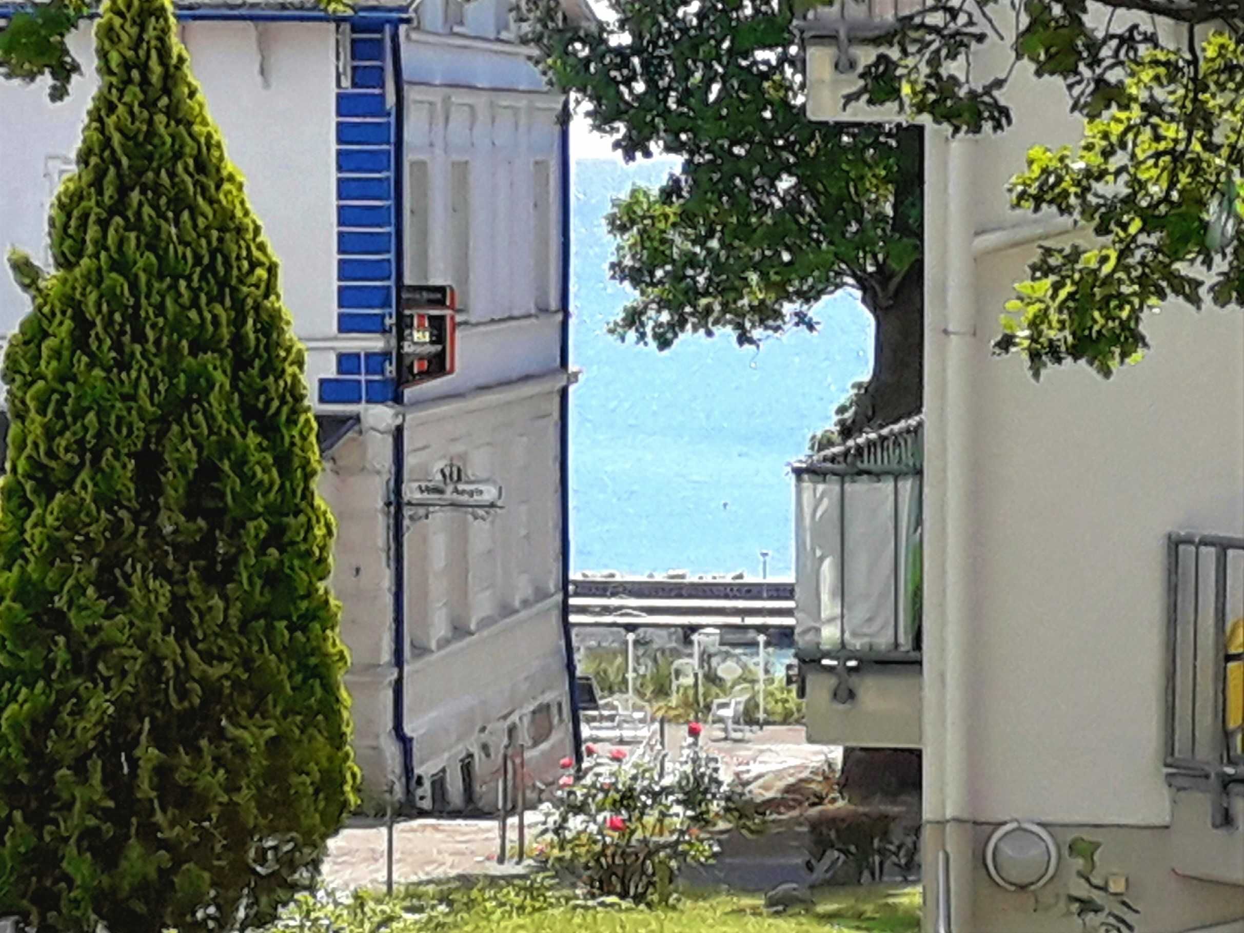 Un edificio con una puerta azul, un letrero que dice "Villa Angina" y una vista de un puente y agua al fondo.