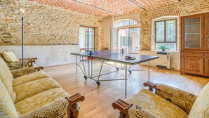 A spacious room with a ping pong table, wooden furniture, and a stone wall. - Beautiful home in Aramengo (AT) (Aramengo (AT))