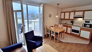 Un apartamento moderno con balcón, comedor y cocina.