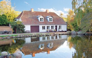 A house with a tiled roof, a garage, and a pond in front. - Stunning home in Sydals with WiFi (Sydals)
