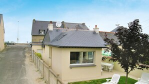 Ein Wohnhaus mit kleinem Garten, einem weißen Stuhl und einem Tisch.