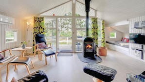 A cozy cabin interior with a fireplace, seating area, and a kitchen. - Cozy home in Henne with sauna (Henne)