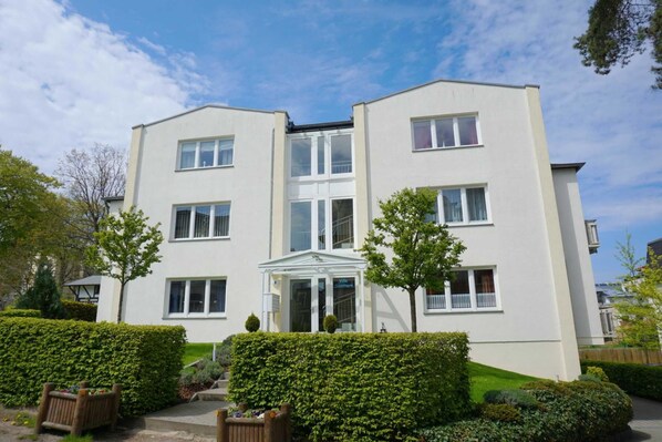 A two-story residential building with a symmetrical facade, large windows, and a central entrance with a glass door. - Apartment 1 - Villa Starfish - near the beach (Heringsdorf)