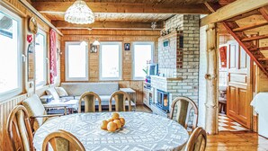 Un intérieur de chalet chaleureux avec un coin repas, une cheminée et un escalier.