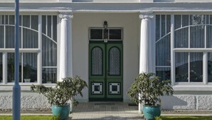 Un edificio con una puerta verde y el nombre 