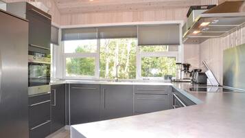 A modern kitchen with a large window, stainless steel appliances, and a clean, minimalist design.