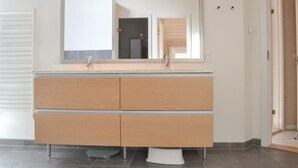 A bathroom with a double sink vanity, a mirror above the sink, and a toilet with a pedestal base. - Cozy home in Oksbøl with sauna (Oksbøl)