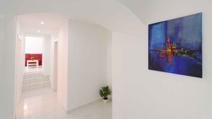 A hallway with a red sofa, a white table, and a potted plant. - Holiday apartment with terrace (Crikvenica)