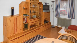 A wooden entertainment unit with shelves, a television, and a radiator. - Ferienwohnung Rinn bei Ibk (Rinn b. Innsbruck)