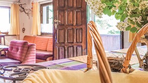 A cozy room with a wooden door, a cushioned bench, and a table with a woven basket.