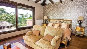 A bedroom with a large bed, a sofa, and a view of the outside. - Stunning home in Elviria (Elviria)