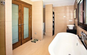 Une salle de bain moderne avec une baignoire sur pieds, une douche à parois de verre et un meuble-lavabo avec un évier et un miroir.