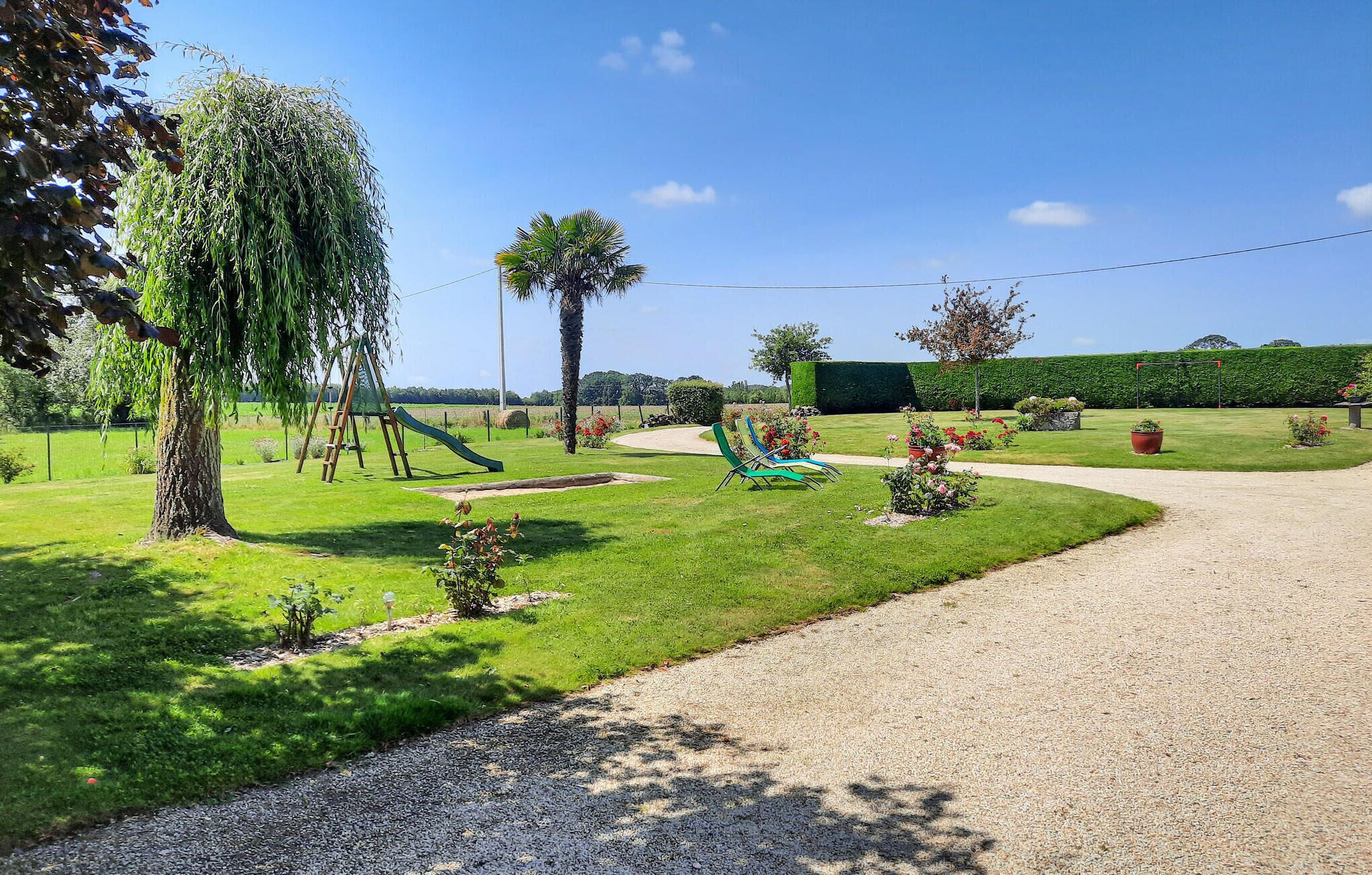 Ein gepflegter Garten mit Kinderspielplatz, inklusive Rutsche und Schaukeln.