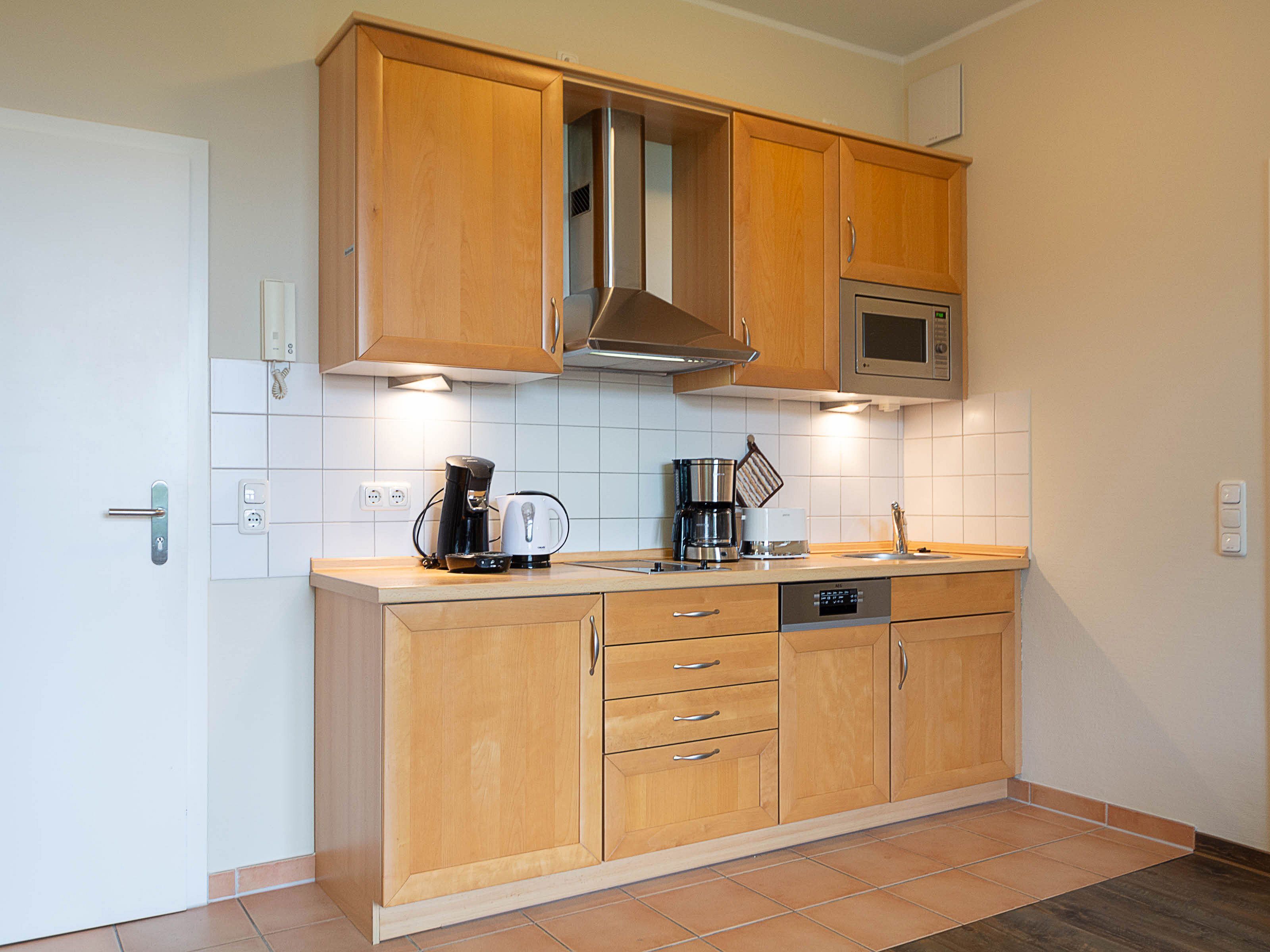 A kitchen with wooden cabinets, a microwave, and a coffee maker.