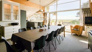 Una cucina moderna con zona pranzo, ampie finestre e vista sull'esterno.