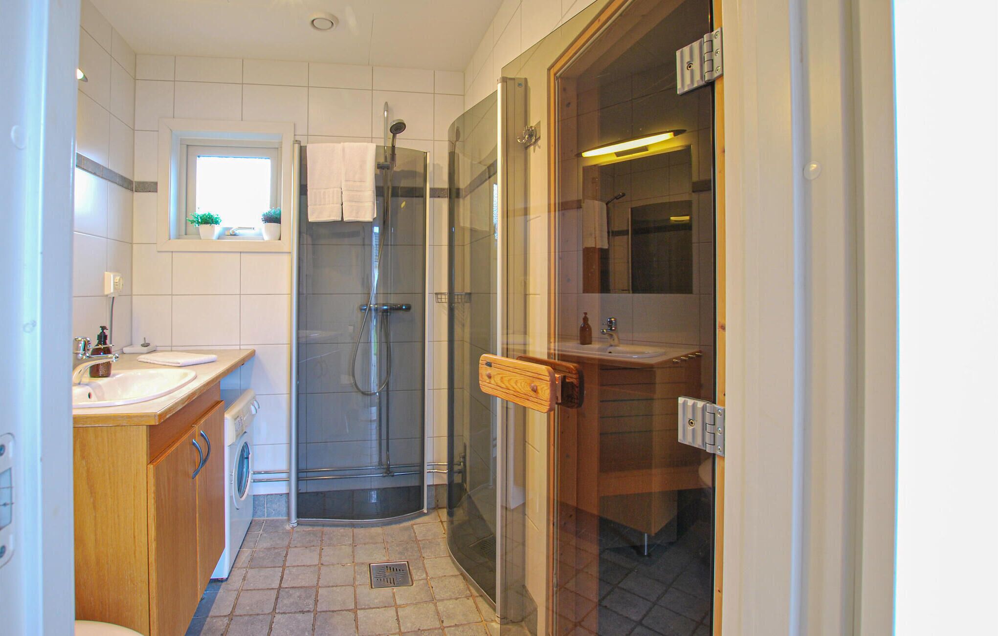 Une petite salle de bain dotée d’une douche à parois de verre, d’un lavabo et d’un miroir.