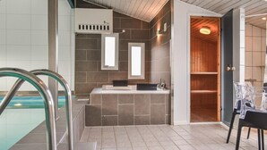 A modern bathroom with a bathtub, a shower area, and a vanity with a mirror.