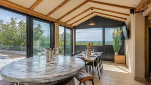 Een eetgedeelte met een ronde tafel, stoelen en uitzicht op de omgeving.