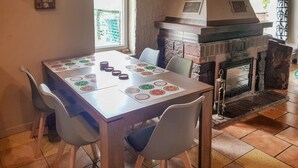 A dining table with placemats, chairs, and a fireplace.