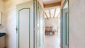 A hallway with a tiled floor leading to a dining area with wooden chairs and a table. - 3 bedroom awesome home in Bédoin (Bédoin)