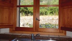Une cuisine dotée d’un plan de travail en pierre, d’un évier en acier inoxydable et d’armoires en bois.