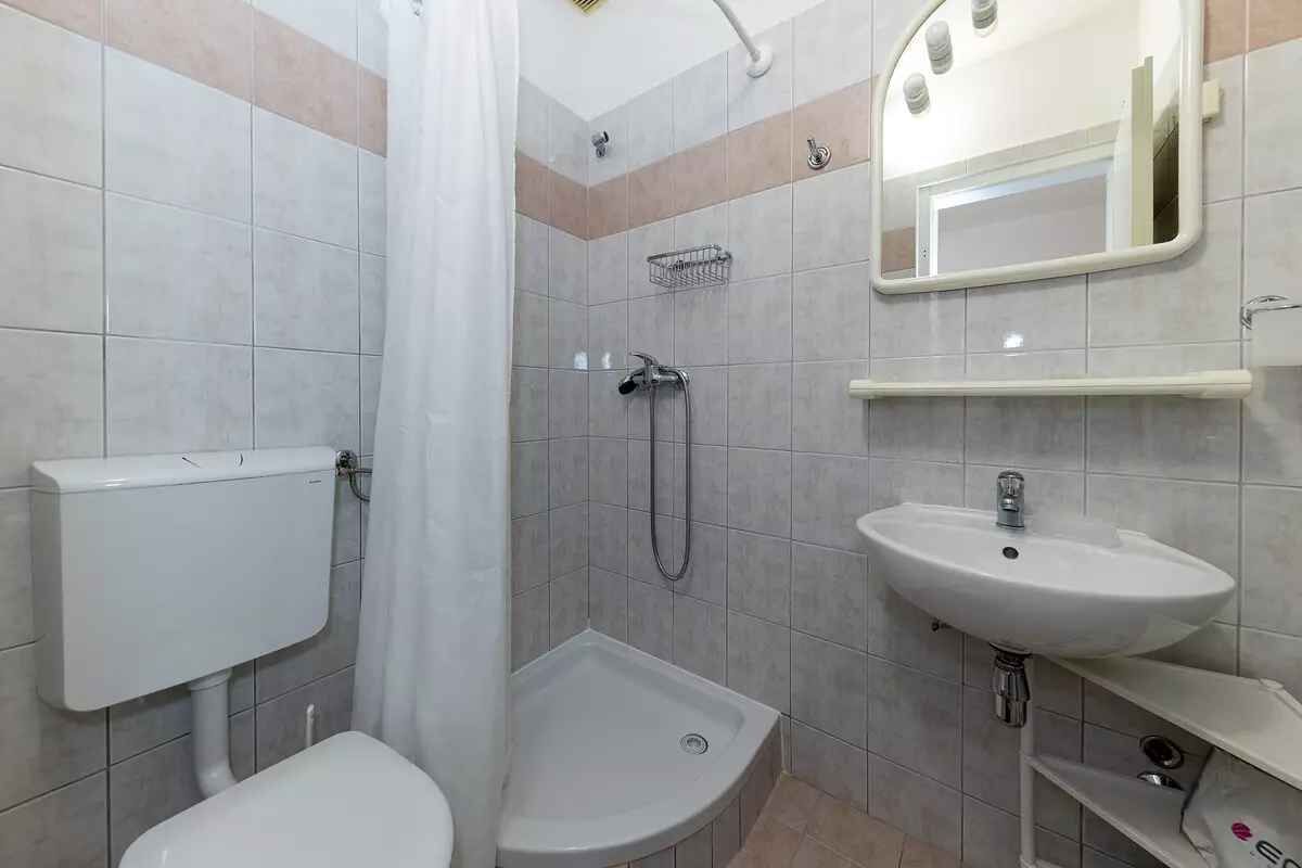Une salle de bain avec des toilettes, une douche et un lavabo.