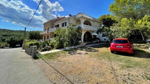 Una casa de dos pisos con balcón y entrada para coches.
