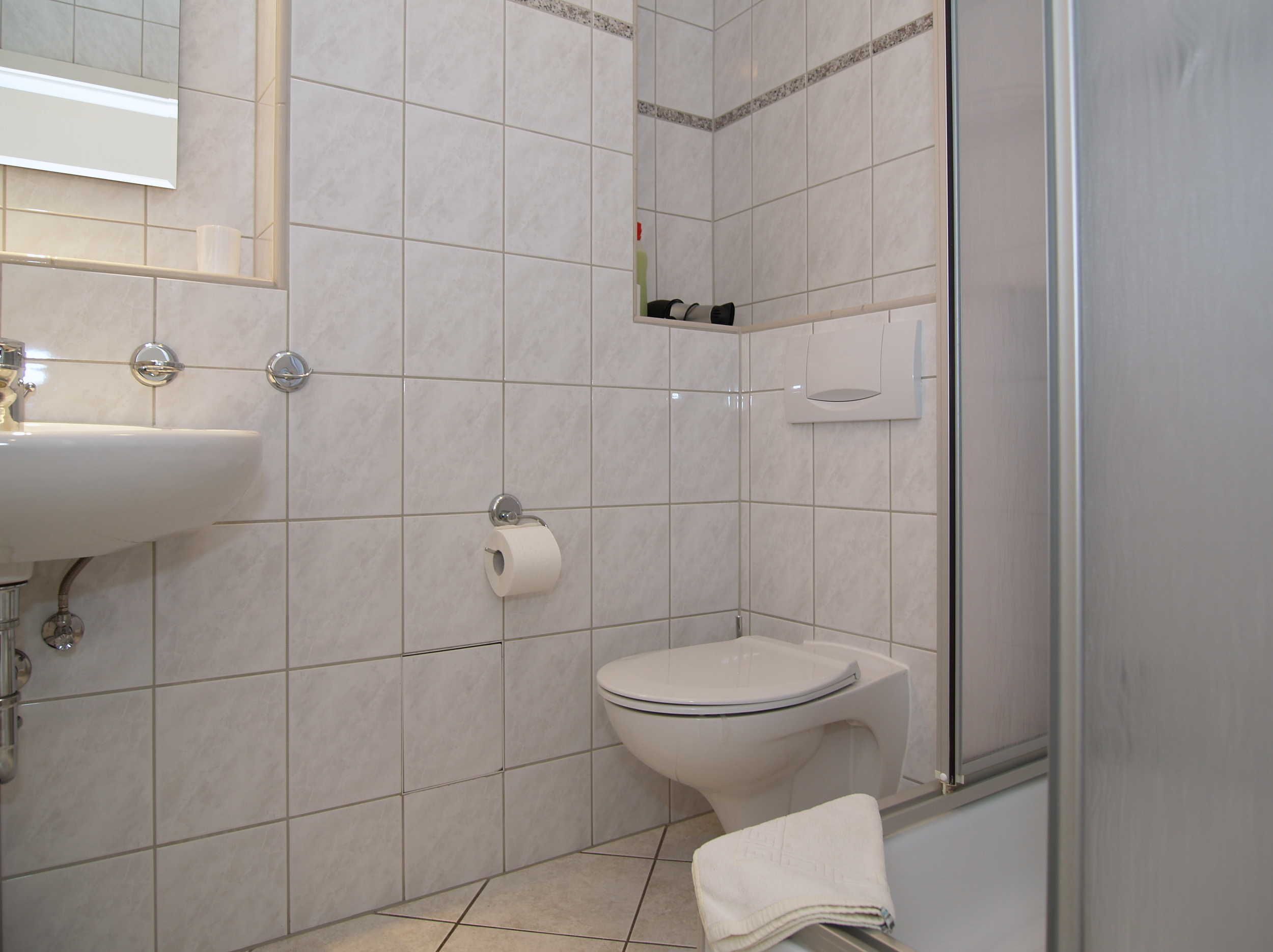 A bathroom with a toilet, sink, and shower.