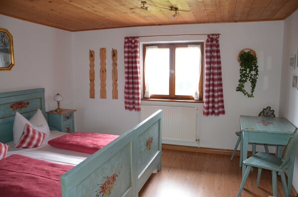 A bedroom with a bed, a desk, and a window with curtains. - FW Haflinger - Hof Roßruck (Fischbachau)