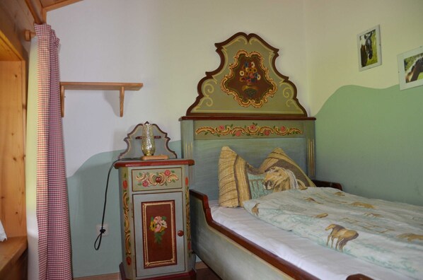 A bedroom with a bed, a dresser, a mirror, and a curtain. - FW Haflinger - Hof Roßruck (Fischbachau)