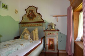 A bedroom with a bed, a dresser, a mirror, and a window with curtains. - FW Haflinger - Hof Roßruck (Fischbachau)